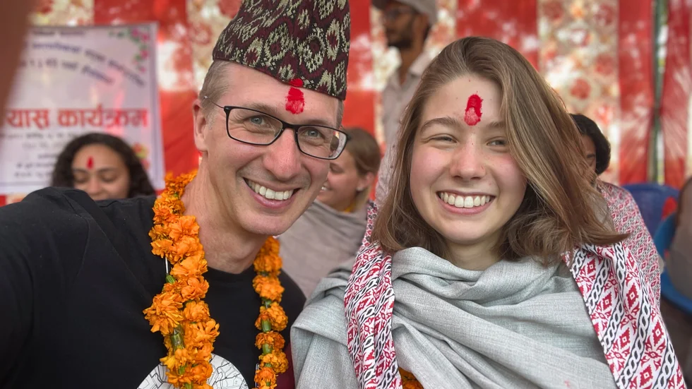 Martin Jägerhorn och dottern Lucie Jägerhorn i traditionella utstyrslar under välkomstceremonin. Martin har en nepali topi på huvudet, och båda har fått varsin tikka på pannan, en hinduisk symbol som används vid högtider.