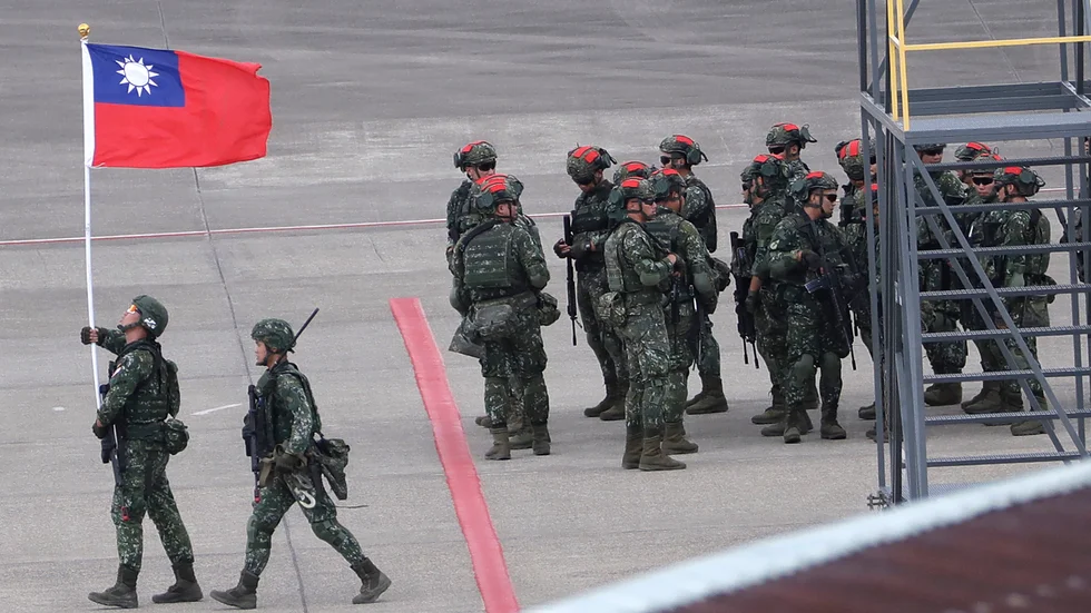 En taiwanesisk soldat håller Taiwans flagga under en stor militärövning i slutet av juli. Den taiwanesiska militären har skakats av flera spionaffärer.