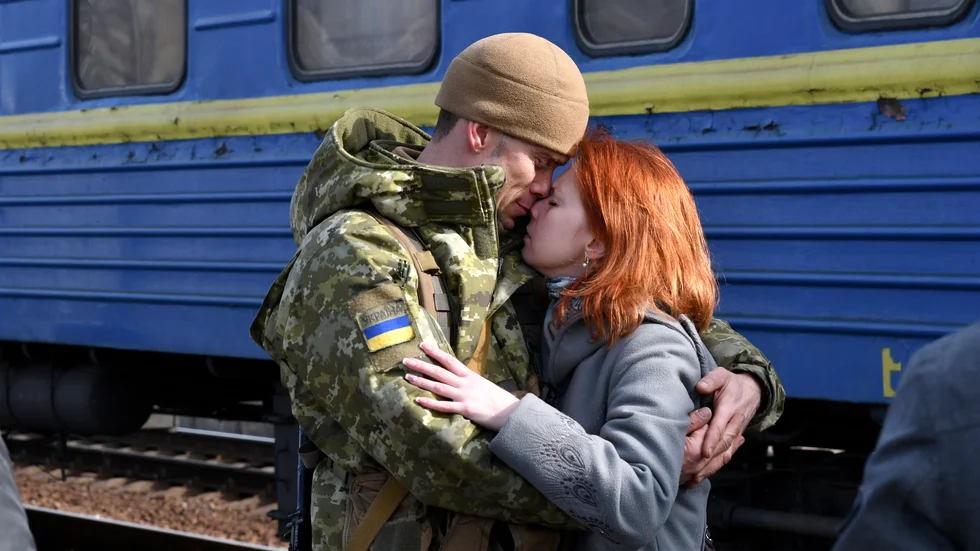 Ett par håller om varandra på perrongen i Kramatorsk, i östra Ukraina, innan kvinnan ska gå ombord ett tåg västerut, kort efter den ryska invasionen i februari 2022.
