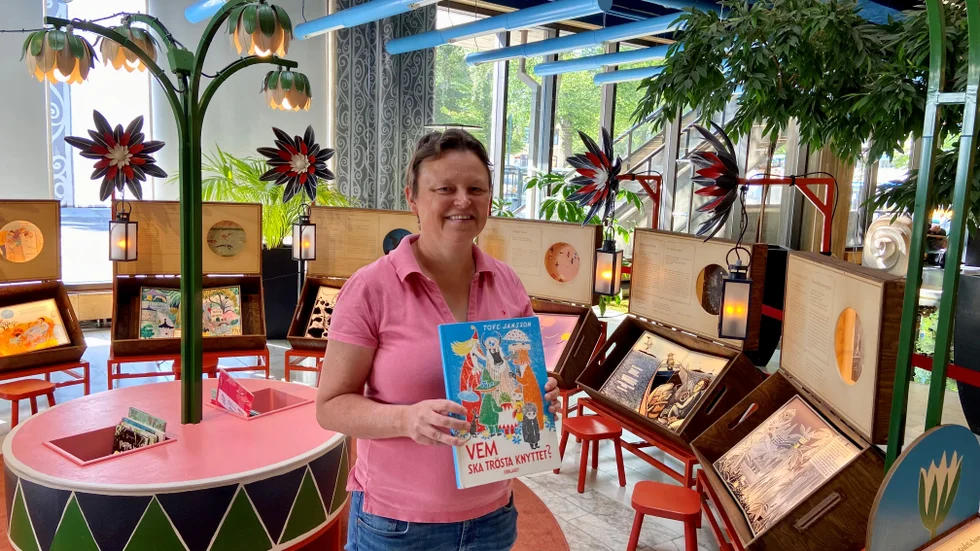 Sara Larsson, bibliotekarie, håller i en bok av Tove Jansson. Men det finns många finska barnboksillustratörer som är konstnärligt intressanta. "Alla är väldigt olika i stilen, och det är kul att se", säger hon.
