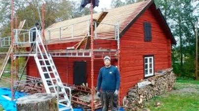 Per Olsson är byggansvarig för takläggningen som sker med specialhyvlade aspspån.