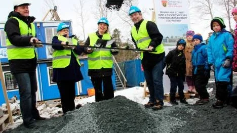 FÖRSTA SPADTAGET. Mats Lowen från entreprenören Rekab, Kerstin Björck-Jansson (C), Lisa Landberg (C) och Tomas Bendiksen (S) satte officiellt i gång byggandet av de 60 nya lägenheterna i Östhammar. Elever från klass 2 vid Kristinelundsskolan ser på. Foto: Astrid Iselidh