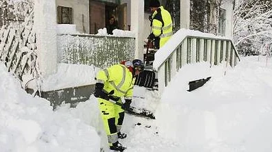 Anna-Lena Jonsson och P-O Swartz från Tierps kommunala servicelag skottar fram Ingvil Stilles verandatrapp.