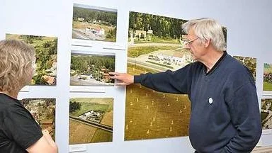 Museichefen Bengt Svensson visar ett flygfoto från Fjärdhundra och den bensinmack som stängde i fjol. Brevid står antikvarie Linda Karlsberg.