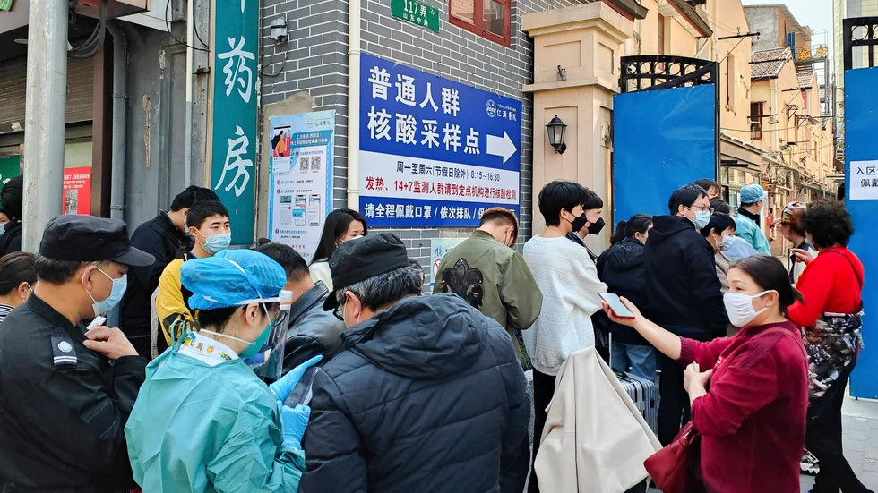 Människor står i kö utanför ett sjukhus i Shanghai för att testa sig för coronaviruset.