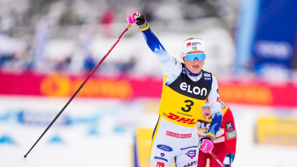 Frida Karlsson höjer armen i en segergest efter att ha spurtat till sig förstaplatsen på 20 kilometer klassiskt i Lillehammer.