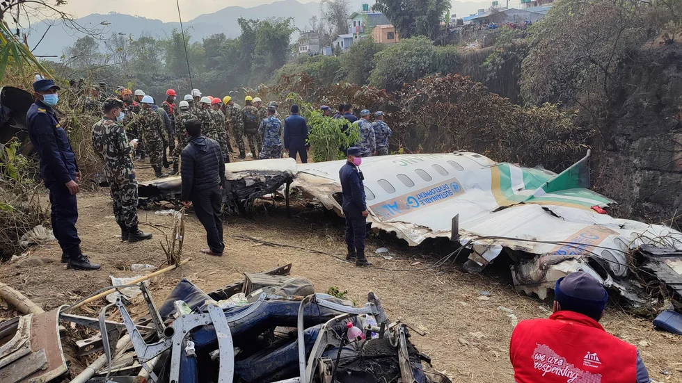 Räddningsarbetare vid vraket av det förolyckade flygplanet i Pokhara på måndagen.
