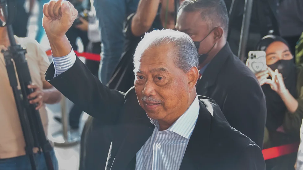 Malaysias tidigare premiärminister Muhyiddin Yassin höjde näven när han infann sig i domstolen i Kuala Lumpur på fredagen.