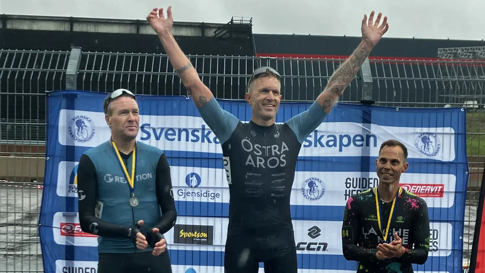 Henrik Lundberg ler brett när han står på prispallen.