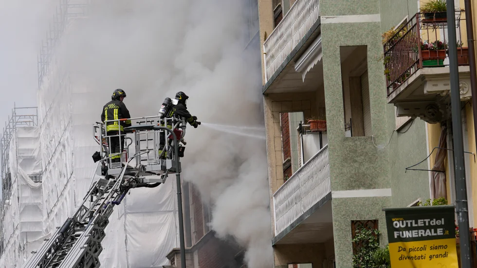 Brandmän i Milano kämpar mot lågorna som spridit sig till en intilliggande byggnad.