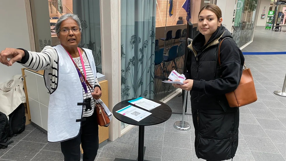 Valförrättaren Sahna Alström visar Daniela Nailyn vägen till valbåset.