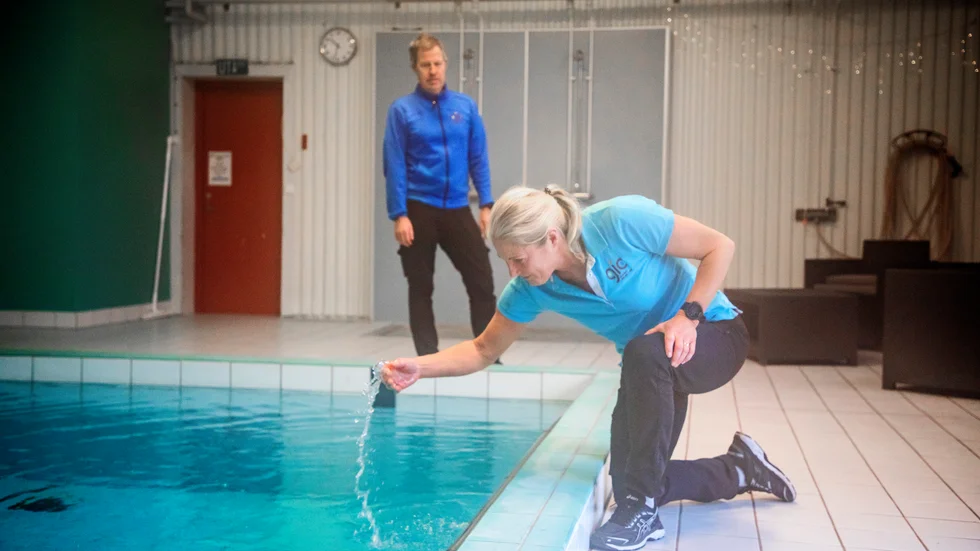 Simhallen i Fårösund är åter öppen. Bilden är från tidigare, när Petra Kalström kände på vattentemperaturen i bassängen och den fortfarande var kall. I bakgrunden syns Peter Nilsson, verksamhetsledare på Gotlands idrottscenter.