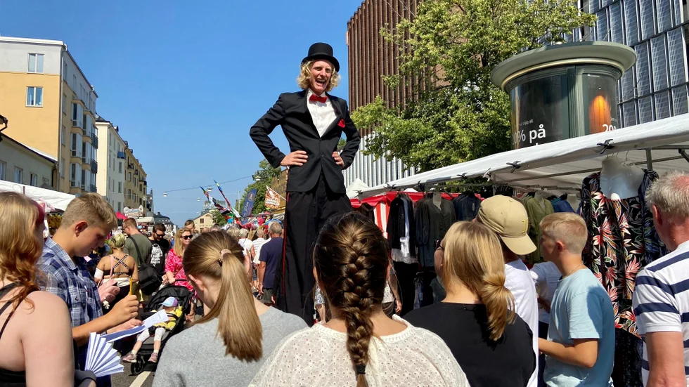 Tre meter långa Benjamin får mycket frågor av folk han möter på marknaden. De flesta handlar om värmen, men här får han en mer ovanlig fråga från elever på Djäkneparksskolan, om demokrati.