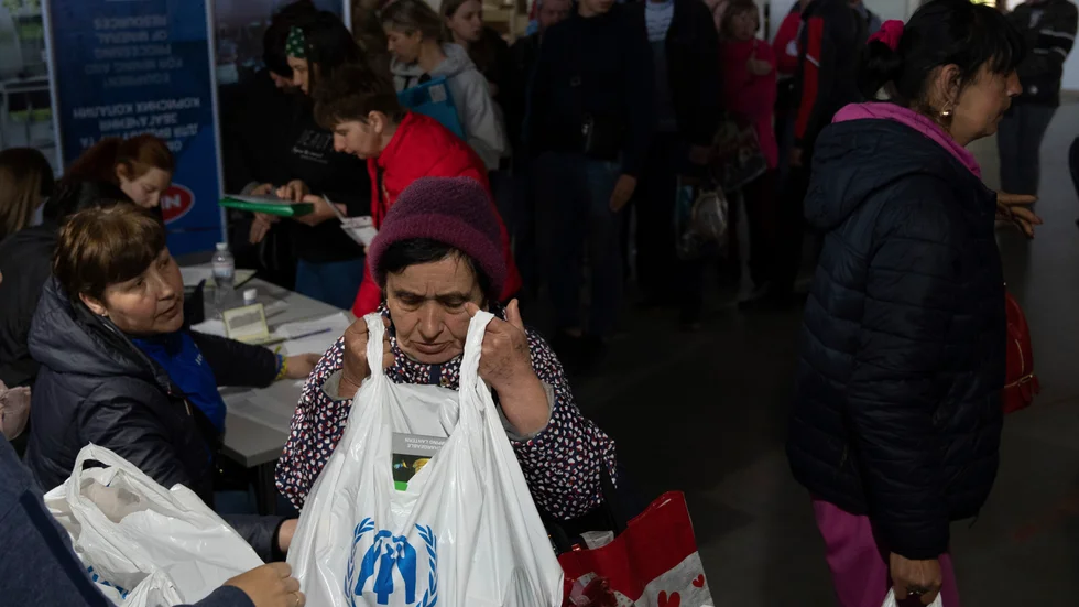 En kvinna får en påse från FN:s flyktingorgan UNHCR vid ett centrum i Zaporizjzja för människor som tvingats bort från sina hem på grund av kriget. Bilden togs i början av maj.