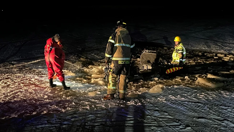 En person har påträffats på isen efter att en skoter gått genom isen.  Fordonet i vattnet på bild är räddningstjänstens.