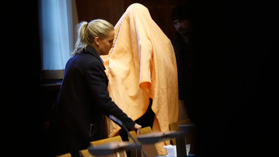 Mannen under en gul filt vid häktningsförhandlingen, dagarna efter att han gripits på en restaurang i Stockholm. Arkivbild.