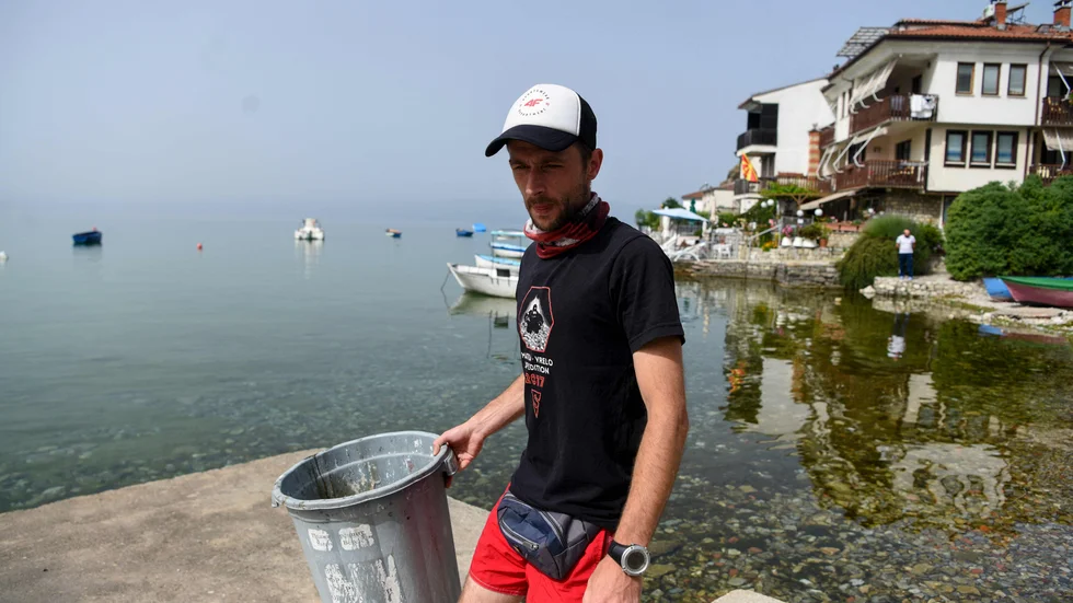 Dykaren och arkeologen Nikola Paskali samlar skräp från Ohridsjöns strand.