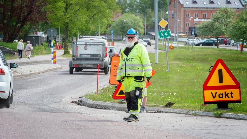 Timo Hirvonen dirigerar trafik under det pågående beläggningsarbetet.