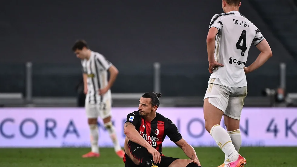Zlatan Ibrahimovic sitter i gräset och tar sig för sitt vänstra knä.