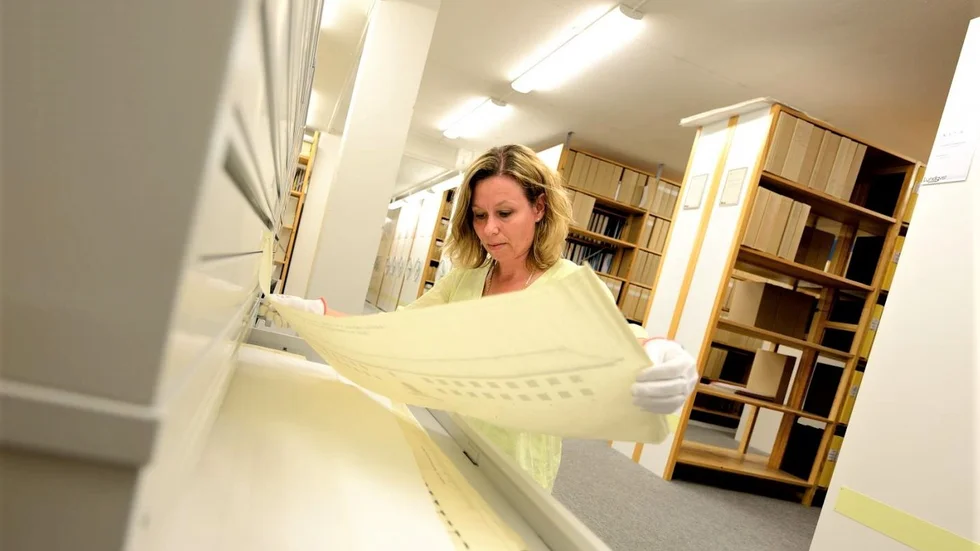 Svenska kyrkans arkiv i Uppsala består av 3 200 hyllmeter arkivmaterial. Här syns Susanna Henriksén som arbetar på kyrkokansliet hålla upp ett av alla dokument från 1800-talet och framåt.