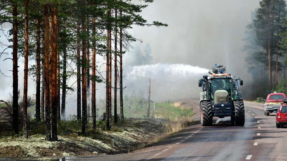 En traktor hjälper till med släckningsarbetet i det branddrabbade området runt Färila i Hälsingland för tre år sedan.