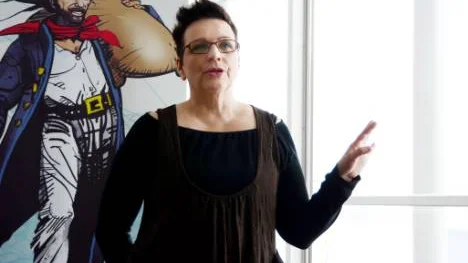 Pia Suonvieri ser fram emot Mustapartamarknaden. I bakgrunden en teckning av den tornedalske bondeledaren/piraten Isak Mustaparta.