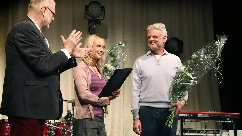 Årets folkbildare. Lars Eklund från Östsam lämnar över priset till Correns reportrar Jenny Eriksen och Johan Sievers.