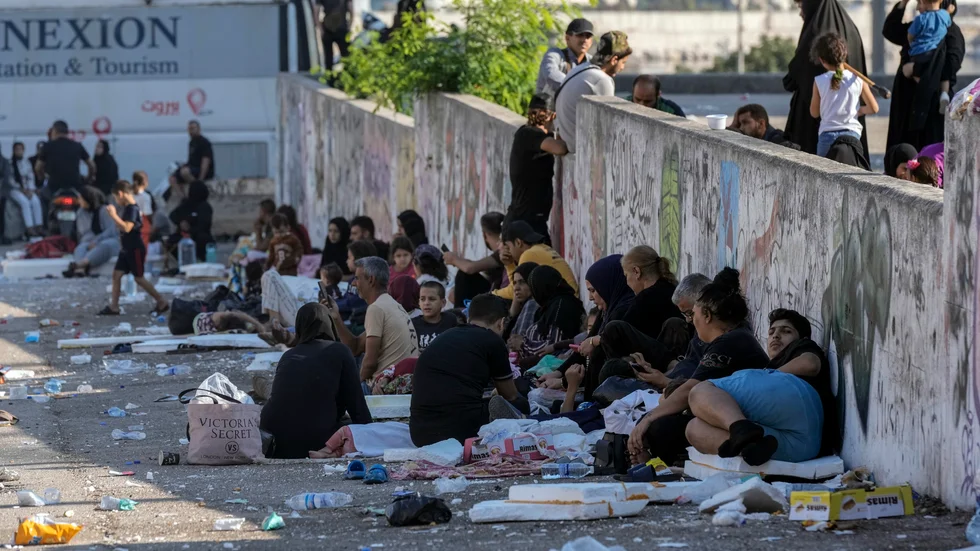 Familjer sitter på marken vid Martyrernas torg i Beirut efter att ha flytt israeliska luftangrepp i stadens södra delar. Bilden är tagen den 28 september.