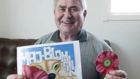 Hans Andersson mångårig majblommegeneral i Arvidsjaur med årets majblomma och majblommeaffisch gjord Caroline af Ugglas.