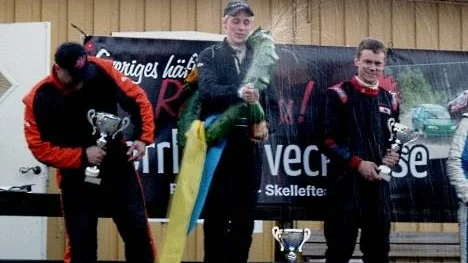 Segraren Andreas Sandberg, Kalix, sprutar segerdrycken. Till vänster syns tvåan Fredrik Tiger, Kalix, och till höger trean Jonas Östman, Älvsbyn.