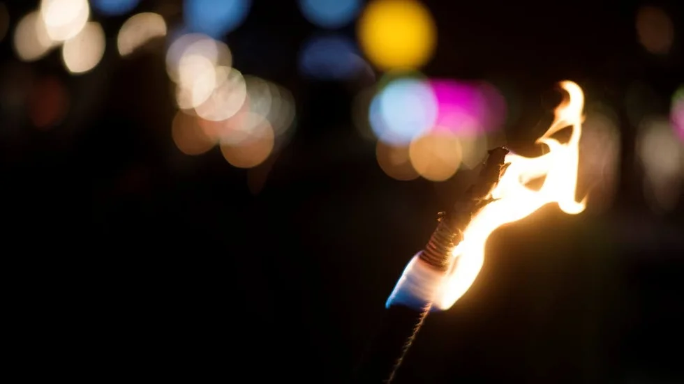 En fackla som symbol för en ljusare framtid överlämnas mellan deltagande länder.