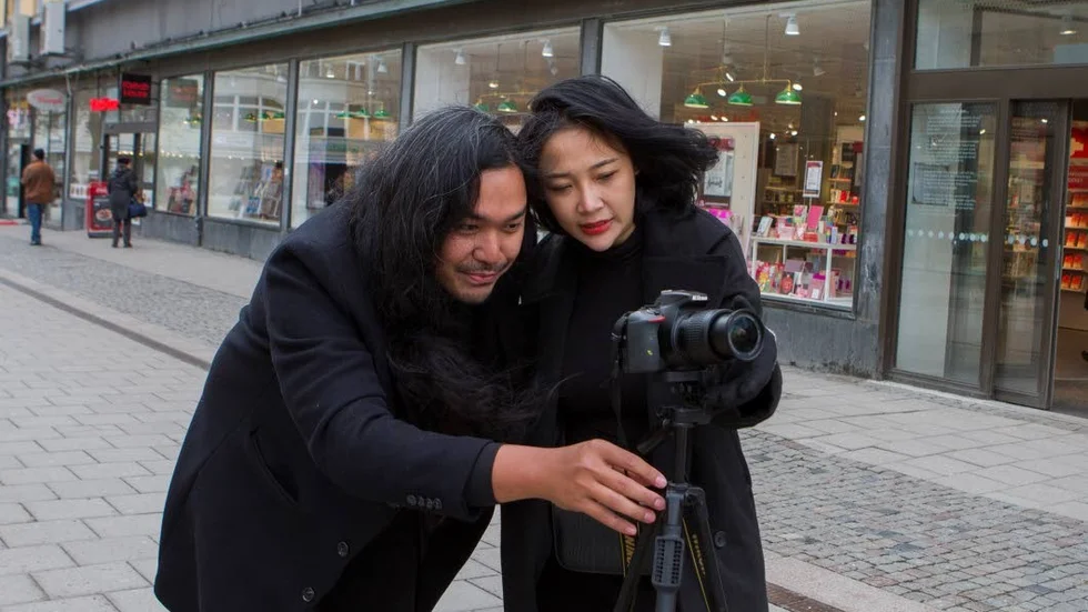 Bird och Film Kongpan ser på bilderna de tagit. Snart ska bilderna läggas upp på sociala medier.