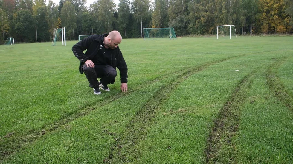 Buskörning. Johan Johansson från Tärnsjö IF vid bilspåren på fotbollsplanen vid Furuvallen som orsakats av buskörning med bil.