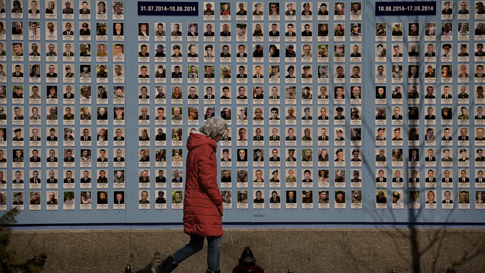 En kvinna går förbi en minnesvägg i Kiev i mars i år, där offer i Rysslands annektering av Krim 2014 hedras. Arkivbild.