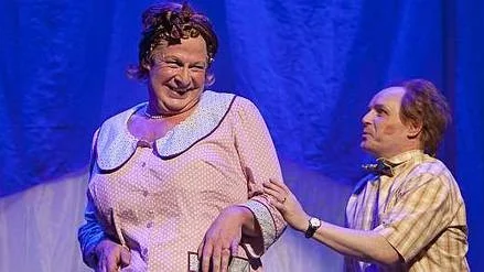 Rolf Lassgård tar det amerikanska hemmafruidealet till oanade höjder i musikalen Hairspray, flankerad av sin kortväxte moatjé Morgan Alling.