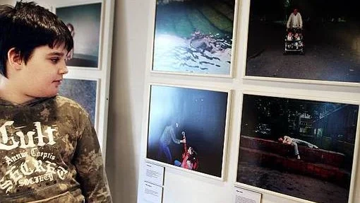 Boris Ivis tittar på några av de bilder som tagits av skolelever i Belgrad till utställningen.