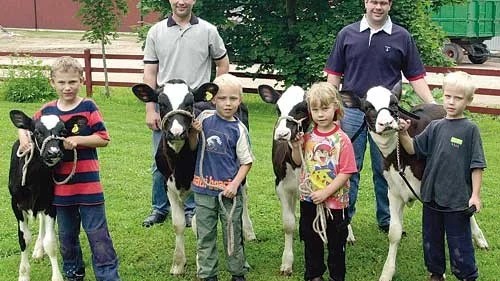 De fyra barnen på Nästgården har tränat länge med sina kalvar för att kunna deltaga i Showman Ship-tävlingen. Här ses Filip, Martin, Louise och Henrik med sina kalvar. I Bakgrunden fäderna Lars och Mats Andersson som är värdar för årets sommarmöte.