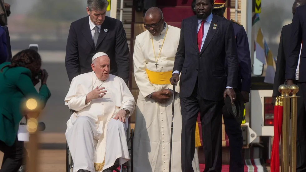 Påve Franciskus välkomnas av Sydsudans president Salva Kiir på huvudstaden Jubas flygplan.