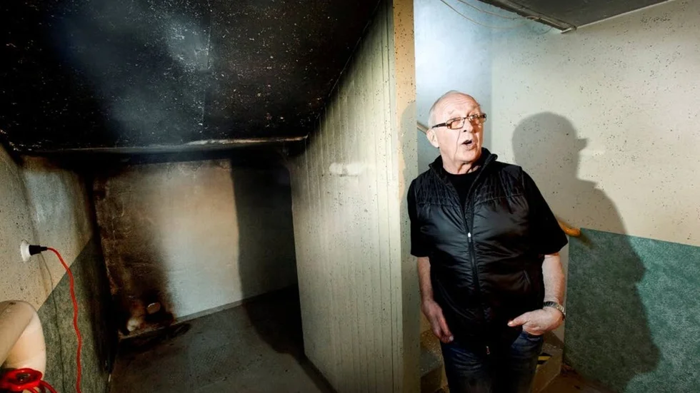 Tage Nordsvahn, boende i det branddrabbade hyreshuset, visar var i källaren den anlagda branden startade. Taket bär synliga spår av mordbranden. (Arkivbild)