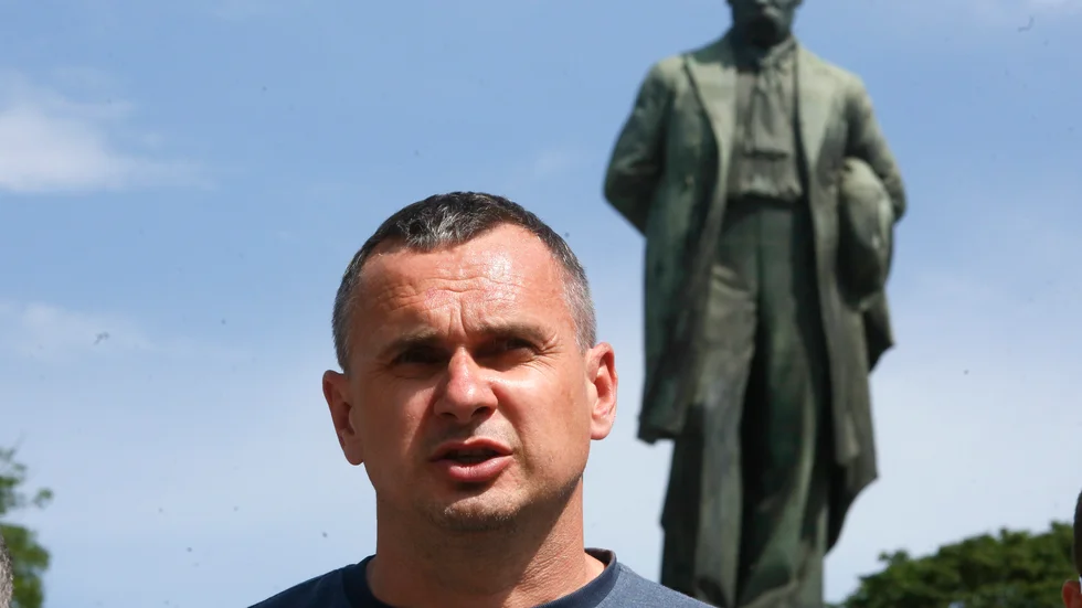 Den ukrainske regissören Oleg Sentsov framför en staty av nationalpoeten Taras Sjevtjenko 2020. Nu har filmmakaren skadats vid fronten i kriget. Arkivbild.