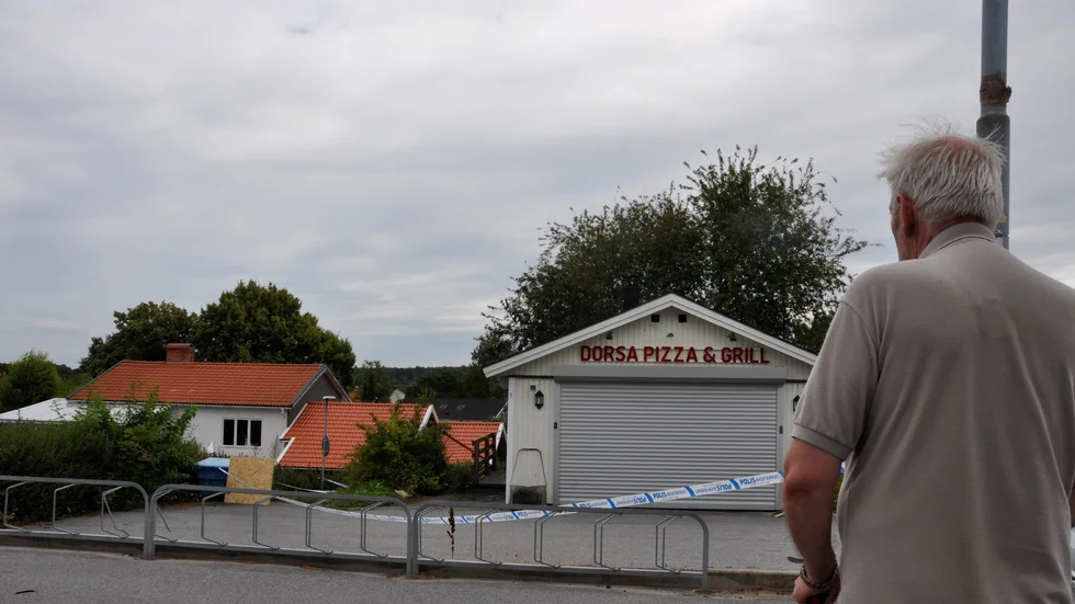Grannen stannade för att titta på den elddrabbade pizzerian. 