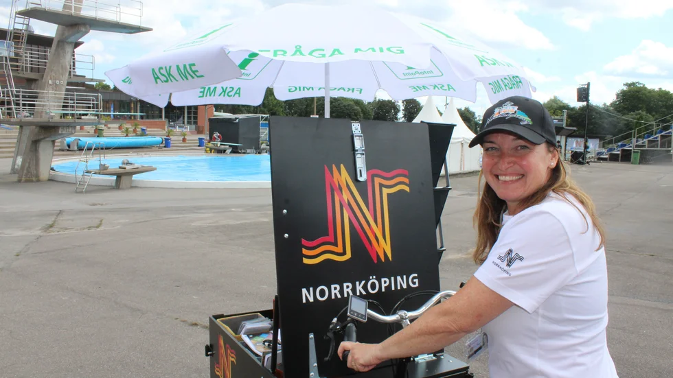Viveca Valgren med sin lådcykel på Sumsim i Centralbadet, för att informera om Norrköping.