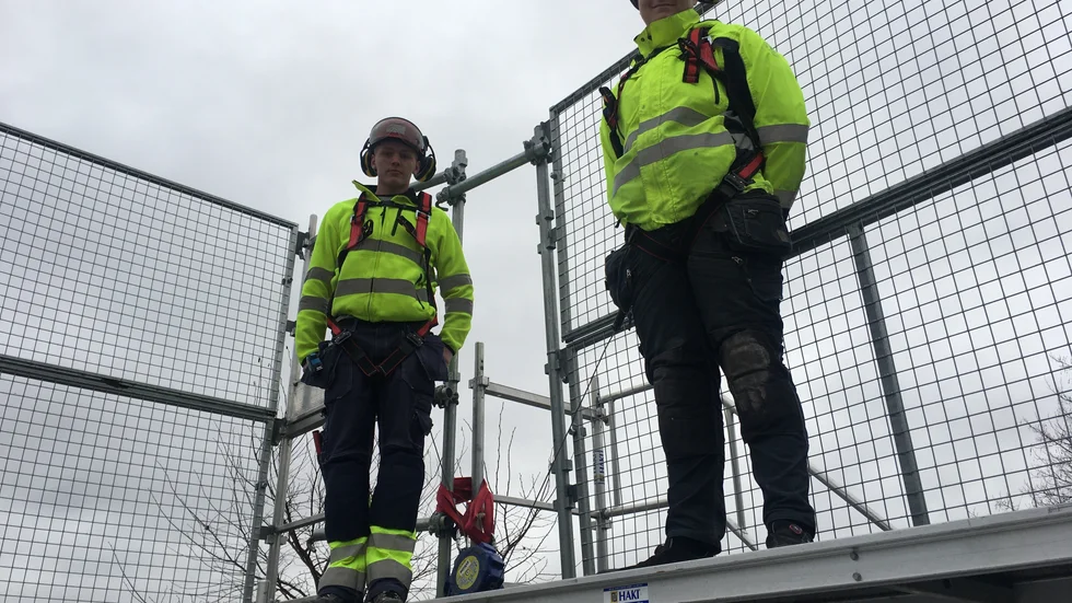 Byggeleverna Ludvig Siljesvärd och Teo Wennertorp med de nya fallskydden som ska förebygga fall framåt i en byggställning.