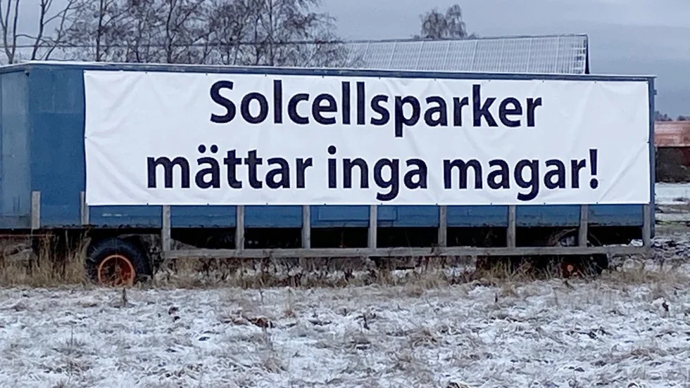 På ett lastbilssläp har något satt upp en banderoll med en prostest mot den planerade solcellsparken i Arvidsbo, strax utanför Tierp.