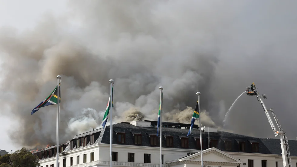 Röken stiger ur parlamentsbyggnaden i Kapstaden i Sydafrika efter att den brand som startade i söndags tagit ny fart igen på måndagseftermiddagen.