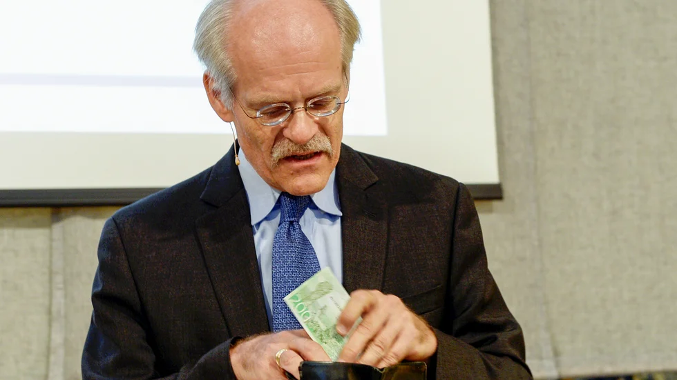 Riksbankschef Stefan Ingves kollar värdet på sedlarna. Arkivbild.