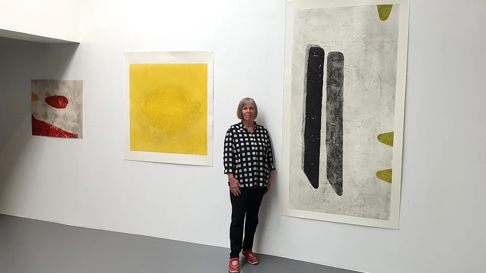 Anne De Geer visar grafik på Östgöta konstförenings jubileumsutställning. För att trycka så här stor grafik måste hon ta med sina plåtar till Bohuslän, där Sveriges största grafikpress finns.  