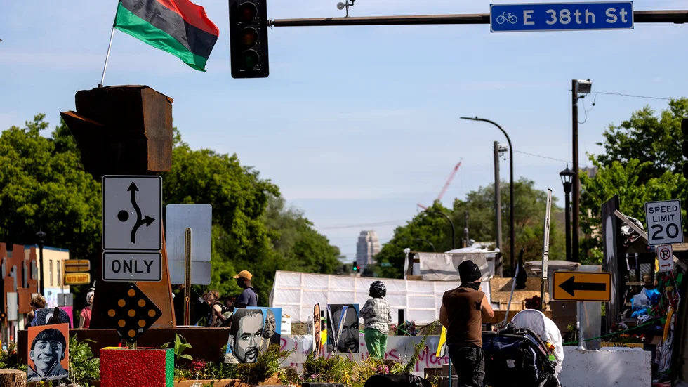 En trafikskylt dirigerar trafiken runt det monument som har rests vid George Floyd Square i Minneapolis. Platsen öppnar återigen för trafik efter att ha varit avstängd i över ett år.