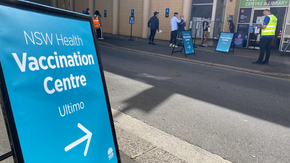 Människor köar för att få sitt covidvaccin i centrala Sydney.