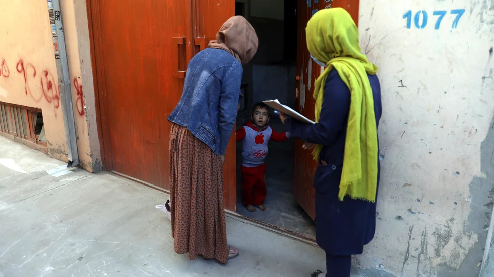 Hälsovårdsarbetare går från dörr till dörr för att erbjuda poliovaccin under en vaccineringskampanj i Afghanistans huvudstad Kabul. Under tisdagen sköts tre kvinnor som arbetade med poliovaccinering i östra Afghanistan. Arkivbild.